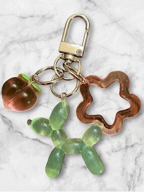 Iridescent Green Balloon Dog Keychain with Peach Charm and Pink Flower